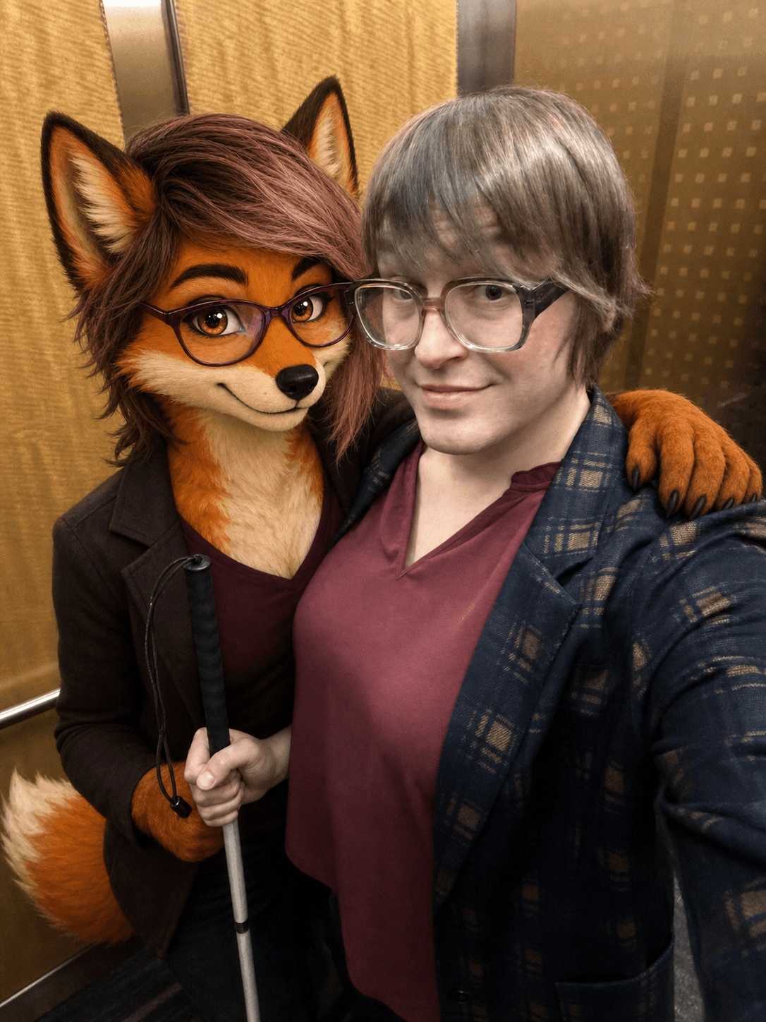 Moxie standing beside a friend in an elevator, recognizable through her orange fur, glasses, hair, ears, and tail.